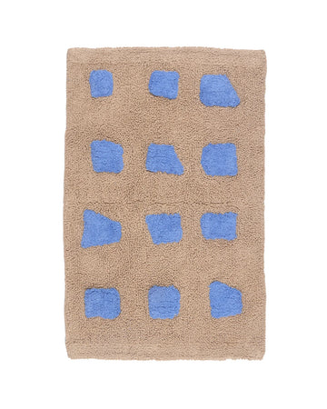 Beige bath mat with blue geometric patterns on a white background
