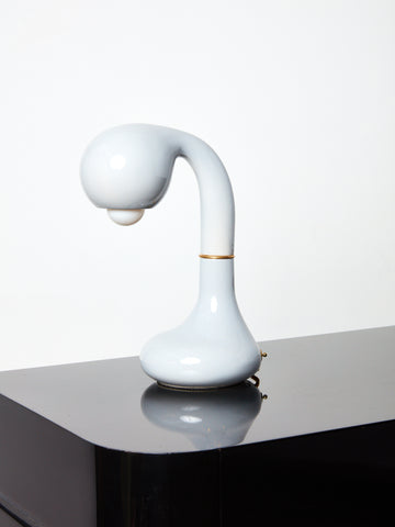 White  Short Ceramic Table Lamp by Entler Studio on a glossy black surface.