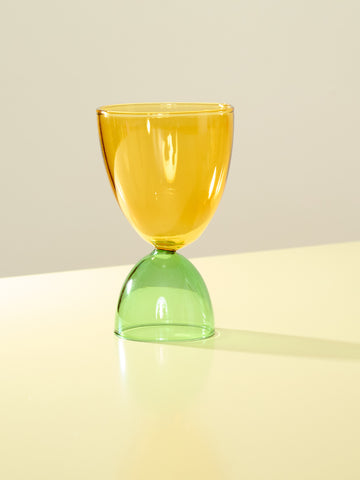 A yellow top and green bottom cocktail glass.