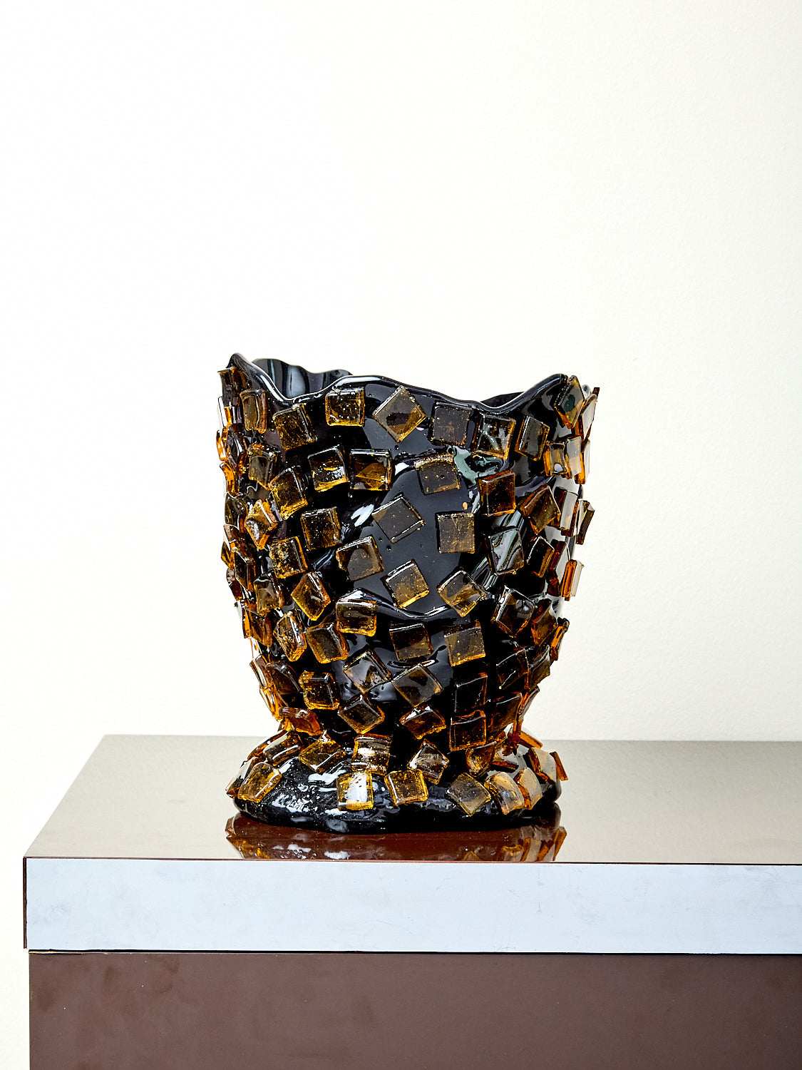 Decorative resin vase with a textured surface on a white background