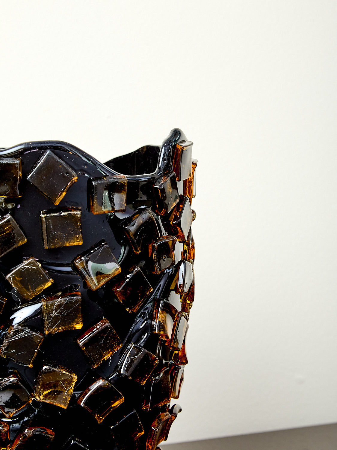 Dcorner detail of decorative resin vase with mosaic tile design.