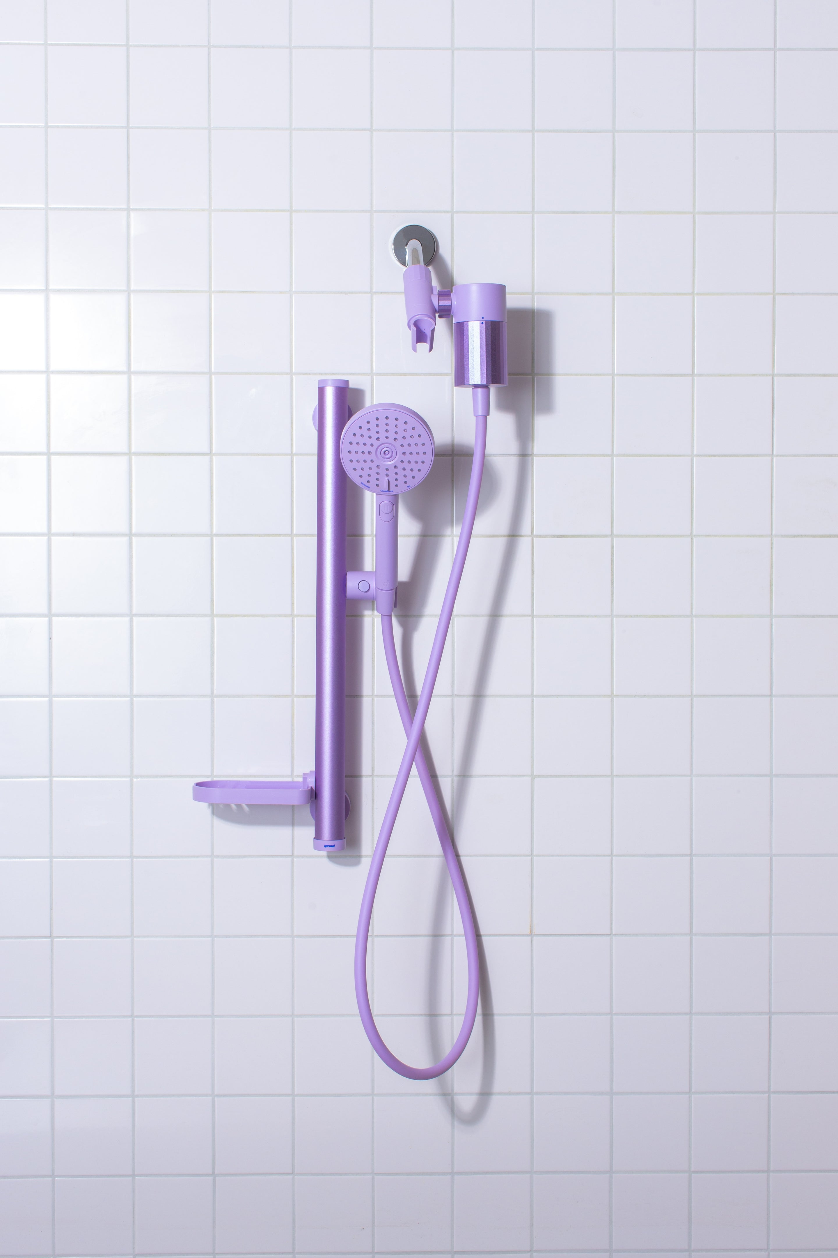 Lavender shower set with handheld showerhead and control handle on a tiled wall background